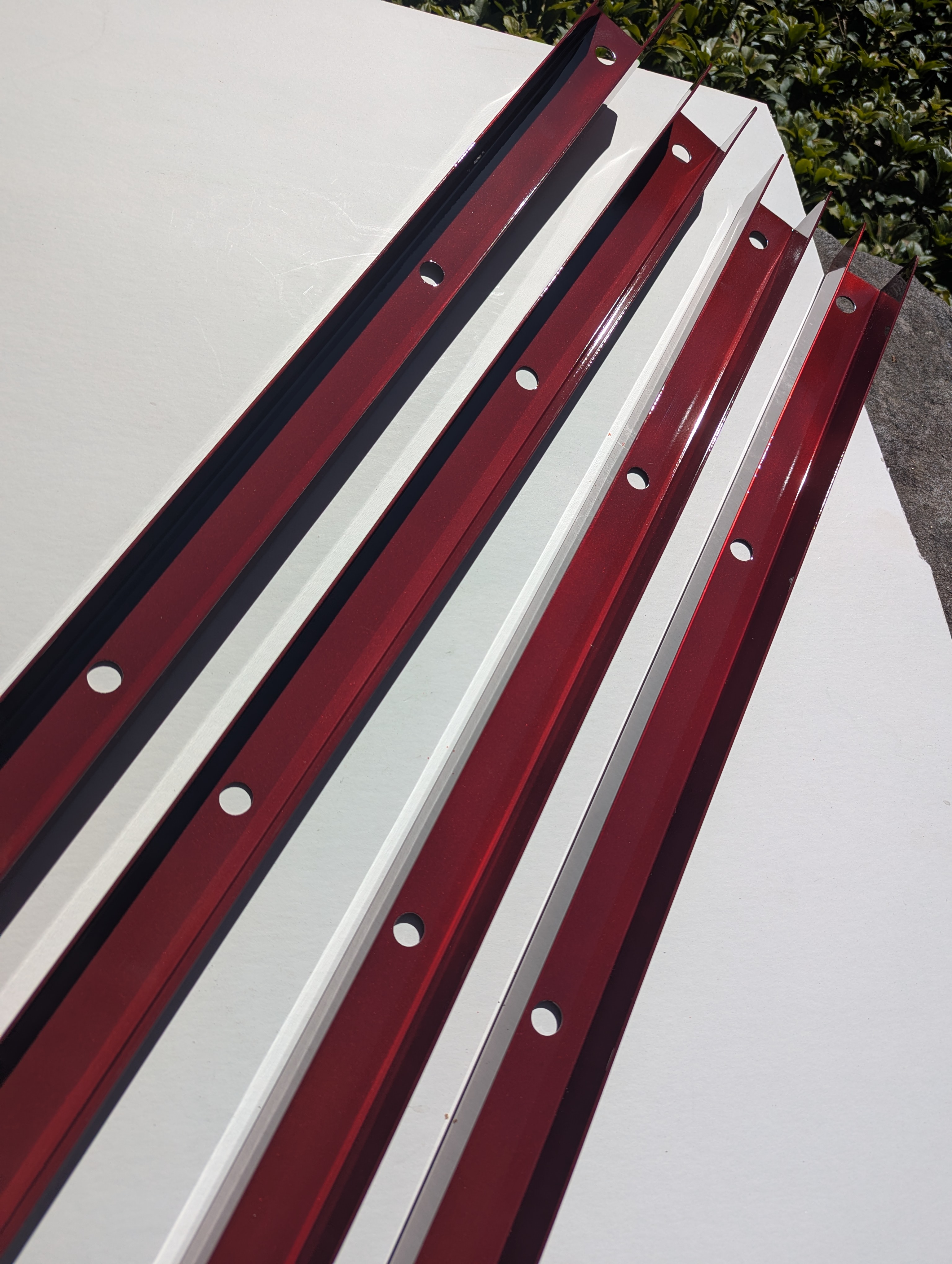 Professional powder coating service on custom metal rail system with candy red finish by Carbon Cavalry in Seattle, Washington